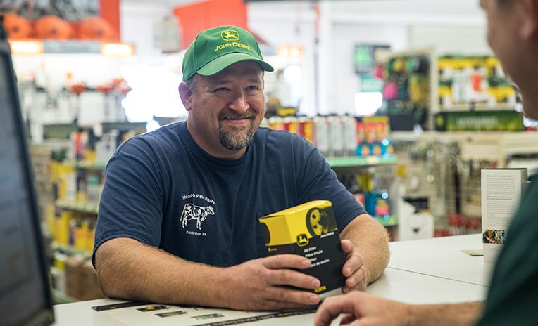 man in John Deere hat at parts counter